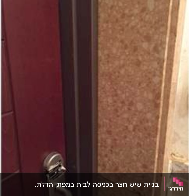 קיר שיש חום ליד דלת עם ידית מתכת